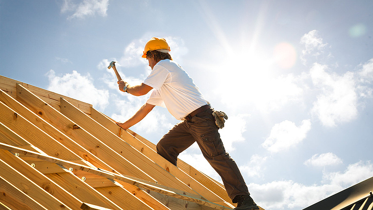 Dachdecker in der Sonne bei der Arbeit