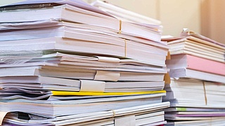 Zwei Aktenstapel auf einem Tisch.