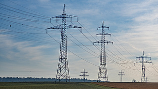 Überlandleitungen auf einem Feld
